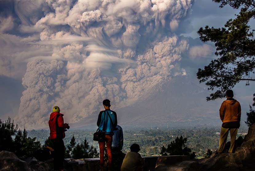 Warga melihat Gunung Sinabung menyemburkan material vulkanik disertai awan panas tampak dari Bukit Gundaling, Brastagi, Karo, Sumatera Utara, Senin (9/2).   (Antara/Endro Lewa)