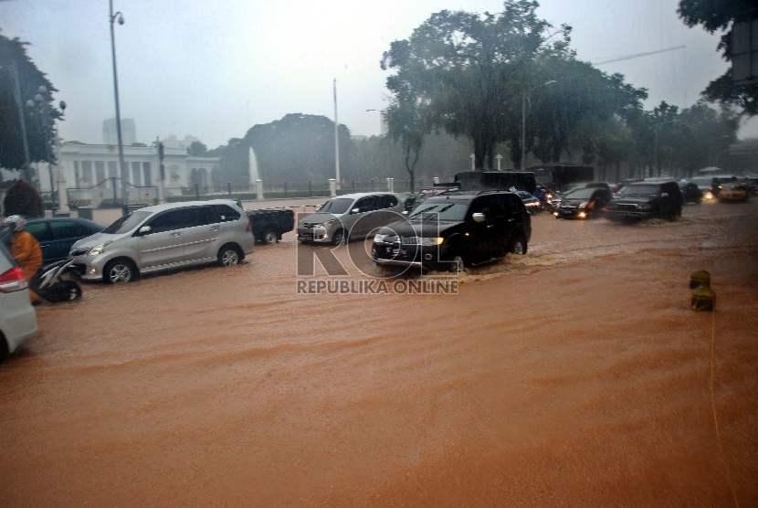  Sejumlah kendaraan terjebak banjir saat hujan deras mengguyur kawasan Jl Medan Merdeka Barat, depan Istana Merdeka, Jakarta   (Republika/Tahta Aidilla)