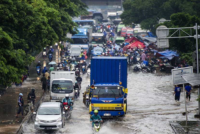   Pengendara motor dan mobil berusaha menerobos salah satu titik banjir di kawasan Jalan Daan Mogot, Jakarta, Selasa (10/2).     (Antara/Ismar Patrizki)