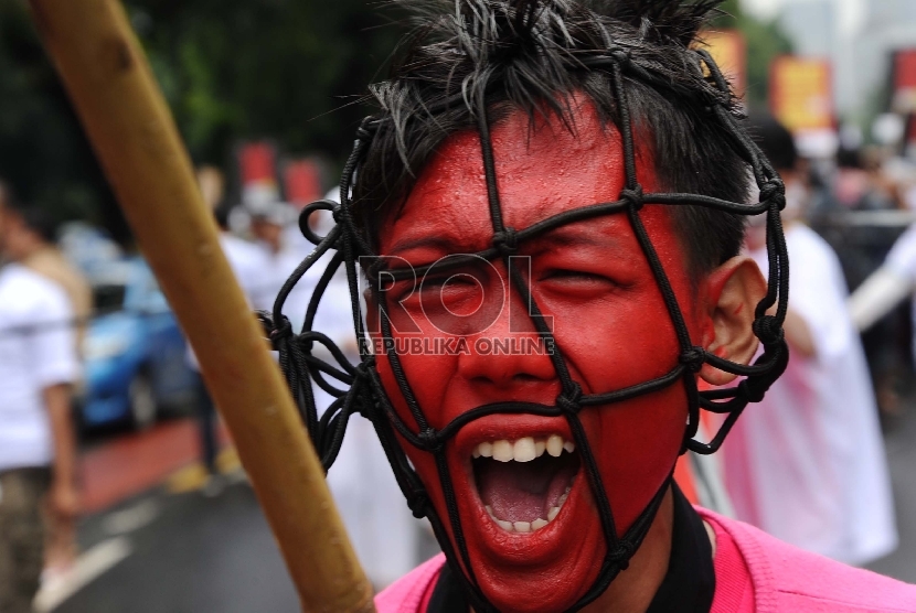 Massa dari berbagai aliansi melakukan aksi teatrikal saat demonstrasi di depan Istana Merdeka, Jakarta, Rabu (11/2).  (Republika/tahta Aidilla)