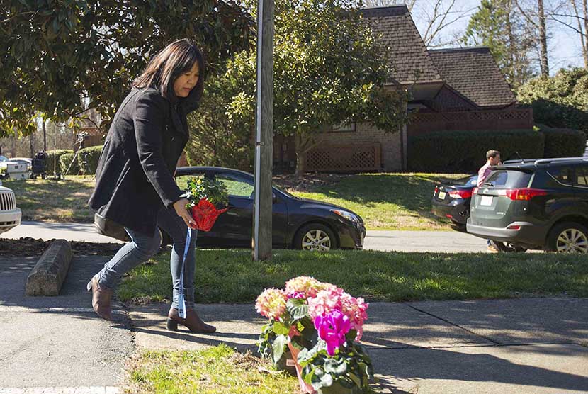  Seorang wanita meletakkan bunga dekat tempat tinggal tiga mahasiswa muslim yang menjadi korban penembakan di komplek Universitas North Carolina, Chapel Hill. (REUTERS/Chris Keane)
