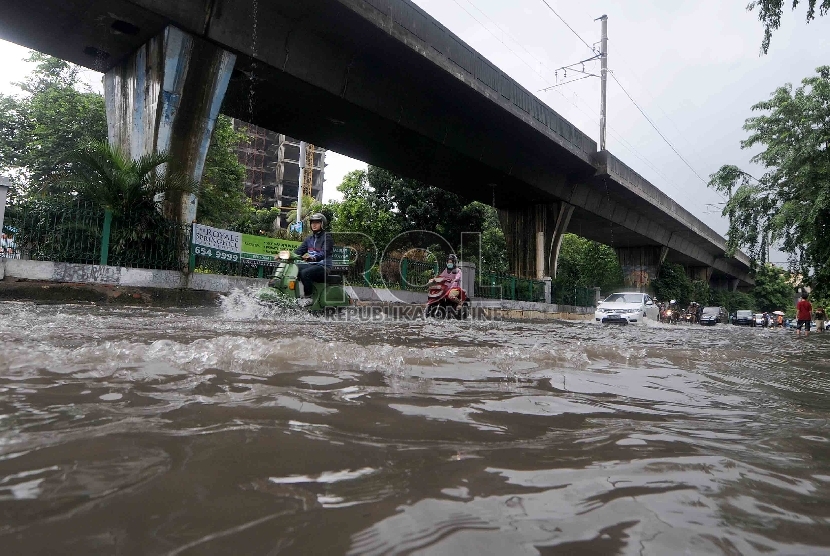 Sejumlah kendaraan melintasi air banjir yang menggenangi jalan di kawasan Cikini, Jakarta Selatan, Ahad (15/2).   (Republika/Agung Supriyanto)