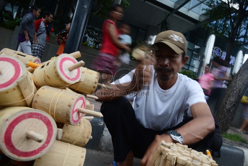 Pedagang mainan tradisional, Parman (42) menjajakan mainan tradisional yang dijualnya saat Car Free Day (CFD) di Jalan Thamrin, Jakarta Pusat, Ahad (15/2).    (Republika/Raisan Al Farisi)