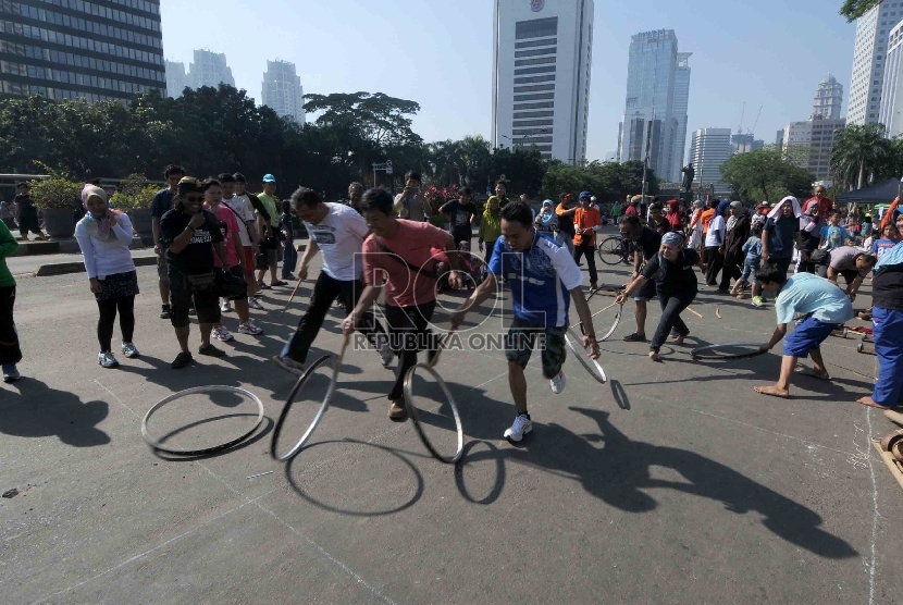 Sejumlah warga mencoba permainan gelindingan yang diadakan oleh Kampoeng Dolanan Nusantara saat Car Free Day di Jakarta, Ahad (22/2).    (Republika/Agung Supriyanto)