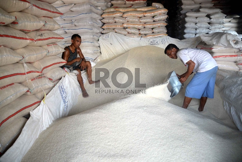Pekerja memasukkan beras ke karung di Pasar Induk Cipinang, Jakarta Timur, Ahad (22/2).  (Republika/Yasin Habibi)