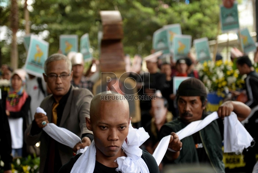 Aktivis yang tergabung dalam Koalisi Masyarakat Sipil Antikorupsi melakukan aksi teaterikal dengan membawa Kuda Troya di Gedung KPK, Jakarta, Rabu (4/3).   (Republika/Wihdan)