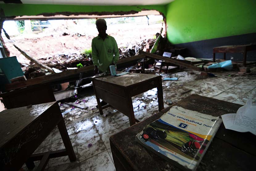  Seorang penjaga membenahi ruang kelas yang rusak di SD Negeri Suka Asih komplek Suka Asih, Kota Bandung, Rabu (4/3)   (foto : Septianjar Muharam)