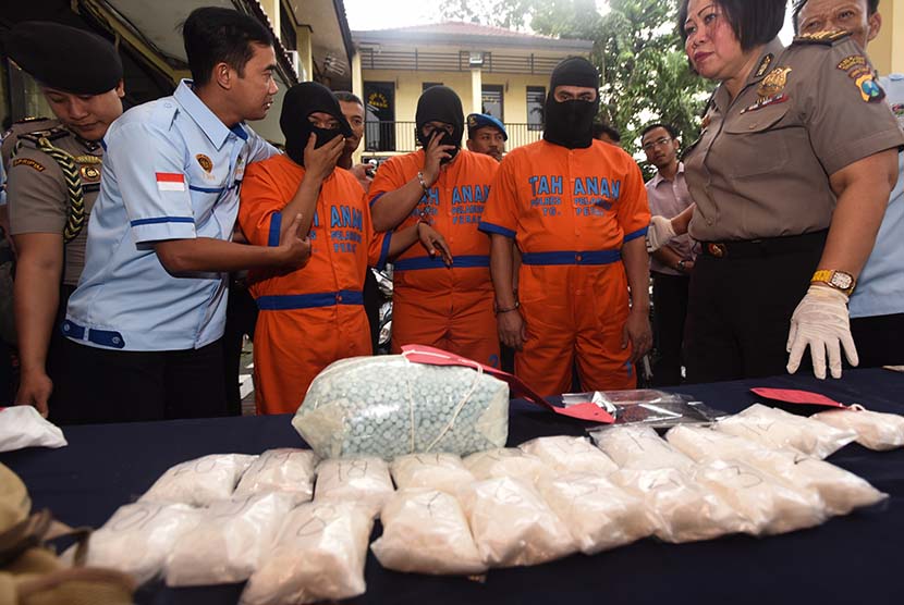  Petugas mengiring tersangka saat gelar kasus penyeludupan narkoba di Polres Tanjung Perak, Surabaya, Jatim, Selasa (10/3).  (Antara/Zabur Karuru/)