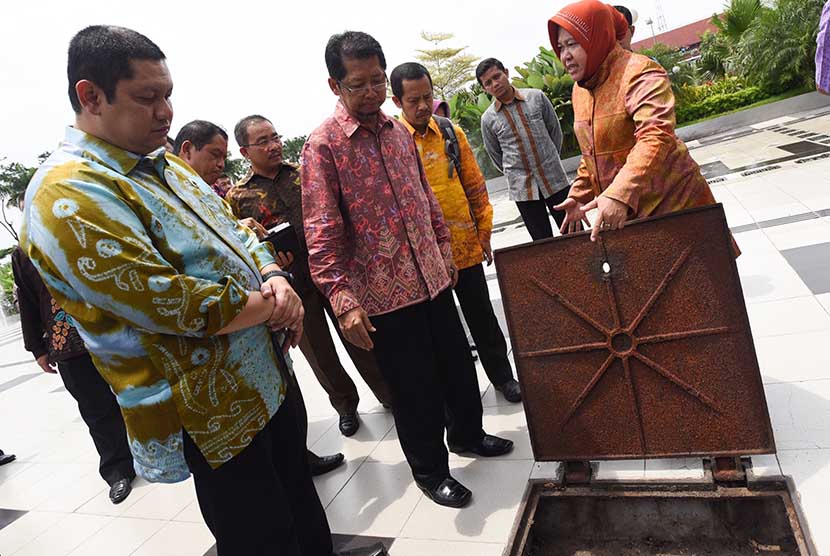 Walikota Surabaya Tri Rismaharini (kanan) memberikan penjelasan mengenai drainase taman kepada sejumlah walikota dan bupati di Balai Kota Surabaya, Jawa Timur, Kamis (12/3). (Antara/Zabur Karuru)