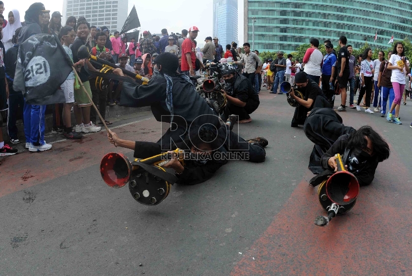   Massa yang tergabung dalam Persatuan Pemuda Peduli Indonesia menggelar aksi teatrikan saat unjuk rasa damai menolak ISIS di kawasan Bundaran HI, Jakarta, Ahad (15/3).   (Republika/Agung Supriyanto)