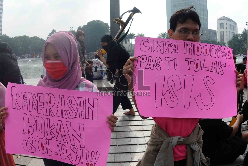   Massa yang tergabung dalam Persatuan Pemuda Peduli Indonesia menggelar aksi teatrikan saat unjuk rasa damai menolak ISIS di kawasan Bundaran HI, Jakarta, Ahad (15/3).   (Republika/Agung Supriyanto)