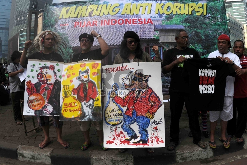 Massa yang tergabung dalam Pijar Indonesia menggelar lukisan para koruptor di Bundaran HI, Jakarta, Ahad (25/3).  (Republika/Agung Supriyanto)