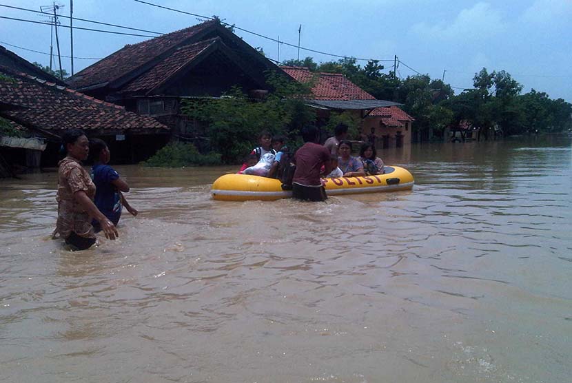   Sejumlah warga di Desa Pilangsari, Kecamatan Jatibarang, Kabupaten Indramayu, diungsikan petugas ke lokasi yang lebih aman dengan menggunakan perahu karet, Senin (16/3).