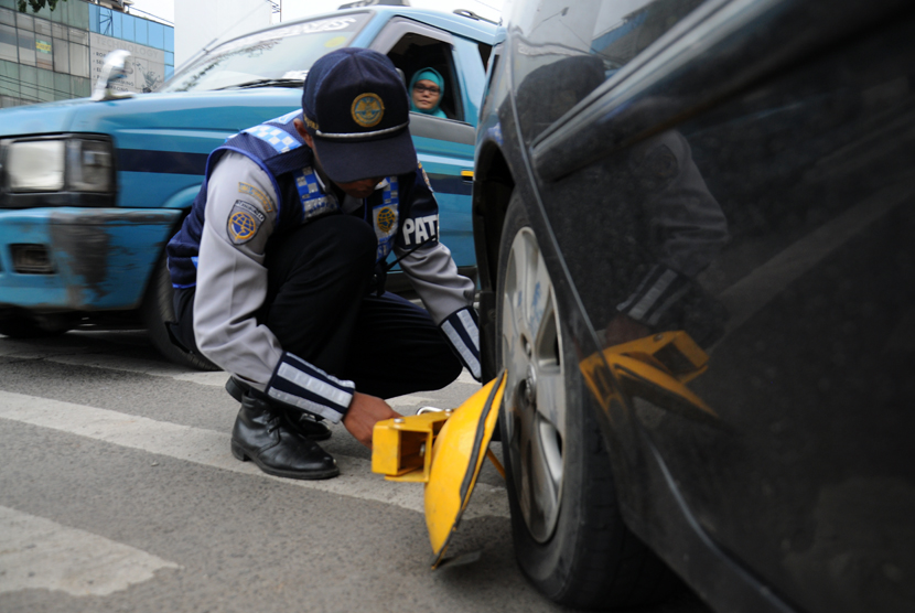   Petugas Dishub gembok mobil yang parkir sembarangan / Ilustrasi 