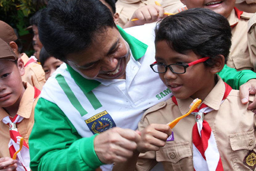  Walikota Depok, Nur Mahmudi Ismail memberi contoh cara menggosok gigi yang benar, saat memperingati Hari Kesehatan Gigi Dunia atau World Oral Health Day di SDN Rangkapan Jaya Depok, Jumat (20/3). (foto : MgROL_39)