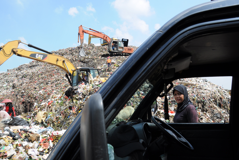 Pekerja menggunakan alat berat menumpuk sampah di TPA Cipayung, Depok, Jawa Barat, Jumat (27/3).  (foto : MgROL_34)  
