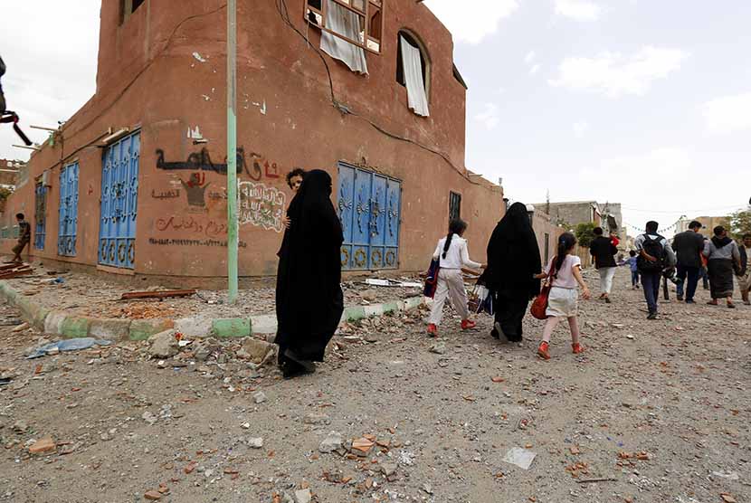  Warga meninggalkan rumah mereka usai serangan udara pasukan koalisi Arab di Sanaa, Yaman, Rabu (8/4).