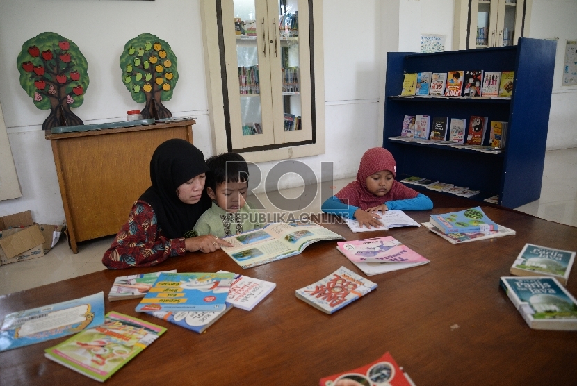 Sejumlah warga dan anak-anak membaca buku koleksi perpustakaan taman ekspresi Surabaya, Jawa Timur, Ahad (12/4).   (Republika/Prayogi)