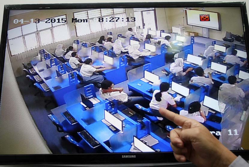 Kepala Sekolah tengah memantau peserta Ujian Nasional berbasis Komputer lewat CCTV di SMA 3 Pamulang, Tangerang Selatan, Banten, Senin (13/5). 