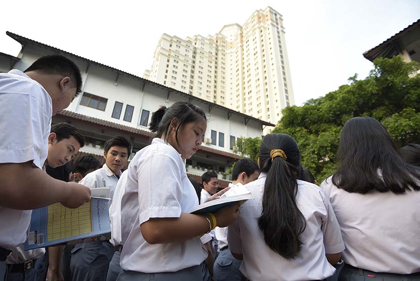   Peserta Ujian Nasional (UN) menyempatkan diri untuk belajar saat menunggu kedatangan Presiden Joko Widodo di SMA N 2 Jakarta, Jakarta, Selasa (14/4).  (Antara/Sigid Kurniawan)