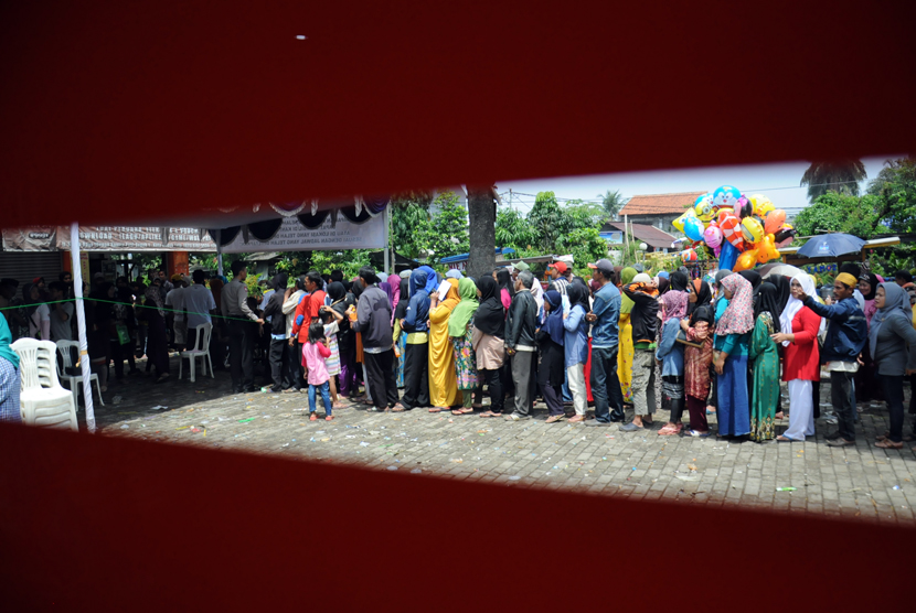  Warga mengantre untuk mendapatkan dana Program Simpanan Keluarga Sejahtera (PSKS) di kantor POS Jalan Rambutan, Depok, Selasa (14/4). (foto : MgROL_34)