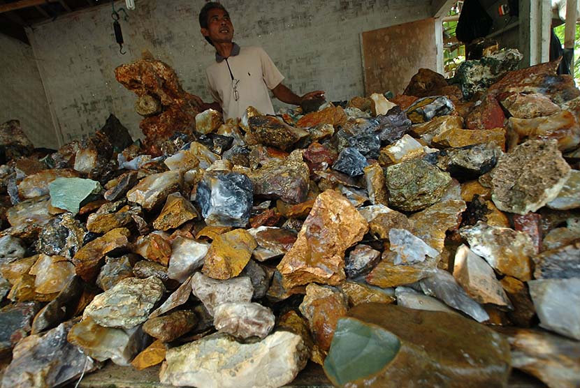 Pedagang bongkahan batu akik menunggu calon pembeli di Kampung Cibarengkok, Kecamatan Bantarkalong, Tasikmalaya, Jawa Barat, Rabu (22/4). (Antara/Adeng Bustomi)