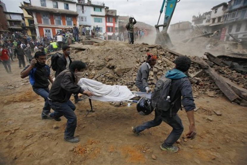   Relawan mengevakuasi korban dari reruntuhan bangunan yang roboh akibat gemba di Kathmandu, Nepal, Sabtu (25/4).