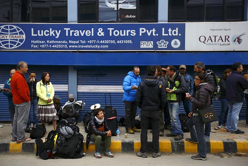  Sejumlah turis berkumpul di depan kantor travel setelah jadwal penerbangan mereka ditunda, Kathmandu, Nepal, Ahad (26/4). (Reuters/Navesh Chitrakar)