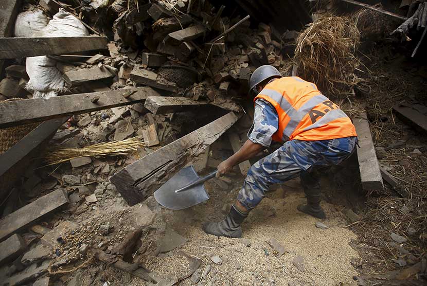   Seorang petugas tengah berupaya mengevakuasi korban dari  reruntuhan bangunan yang hancur akibat gempa bumi di Bhaktapur, Nepal, Ahad (26/4). (Reuters/Navesh Chitrakar)