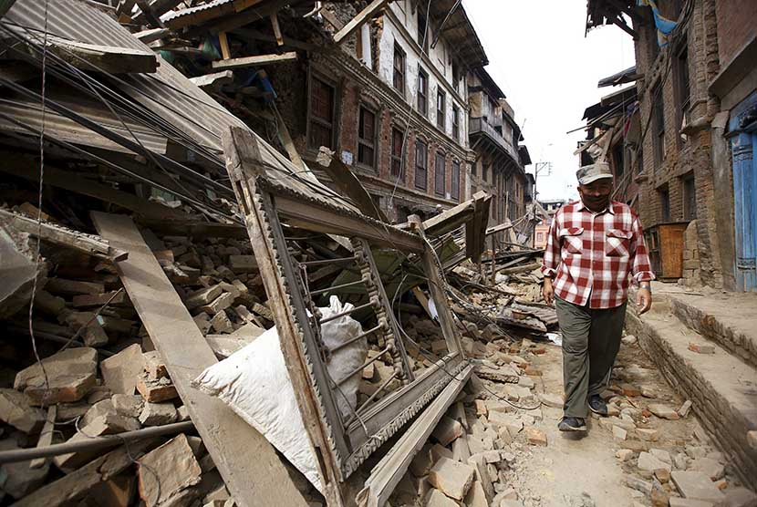  Seorang warga melitasi bangunan yang hancur akibat gempa bumi di Bhaktapur, Nepal, Ahad (26/4). (Reuters/Navesh Chitrakar)