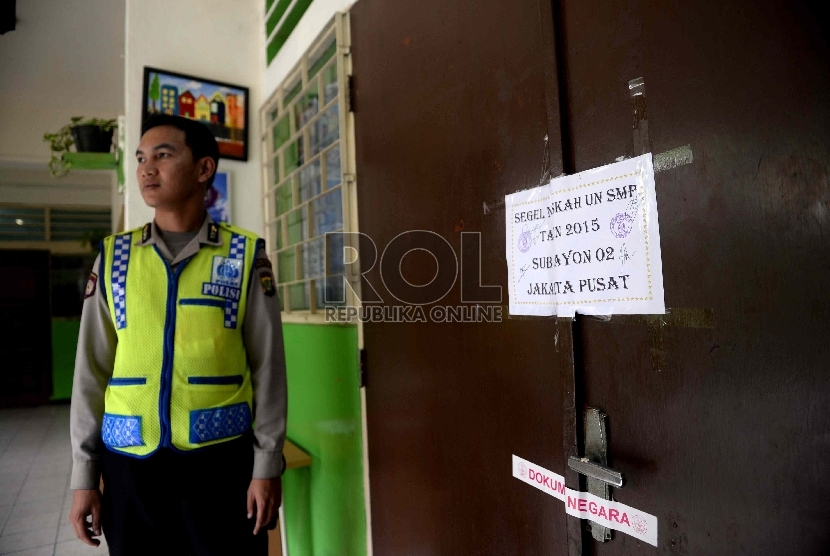  Petugas melakukan penjagaan naskah soal UN SMP di SMPN 216 Jakarta Pusat, Ahad (3/5). (Republika/Wihdan)