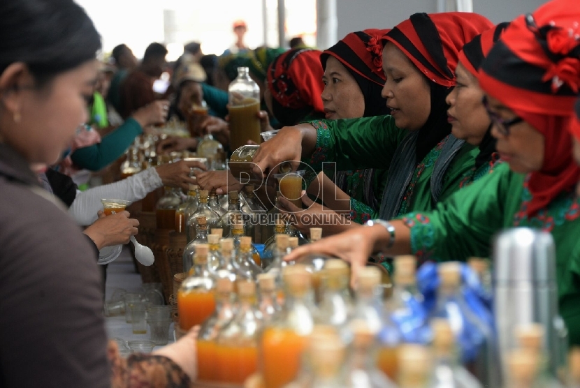 Para pedagang jamu melayani konsumen saat acara Makan bakso dan minum jamu bersama dalam peringatan Hari Konsumen Nasional di Lapangan Parkir Gedung Sarinah, Jakarta, Ahad (10/5).  (Republika/Prayogi)