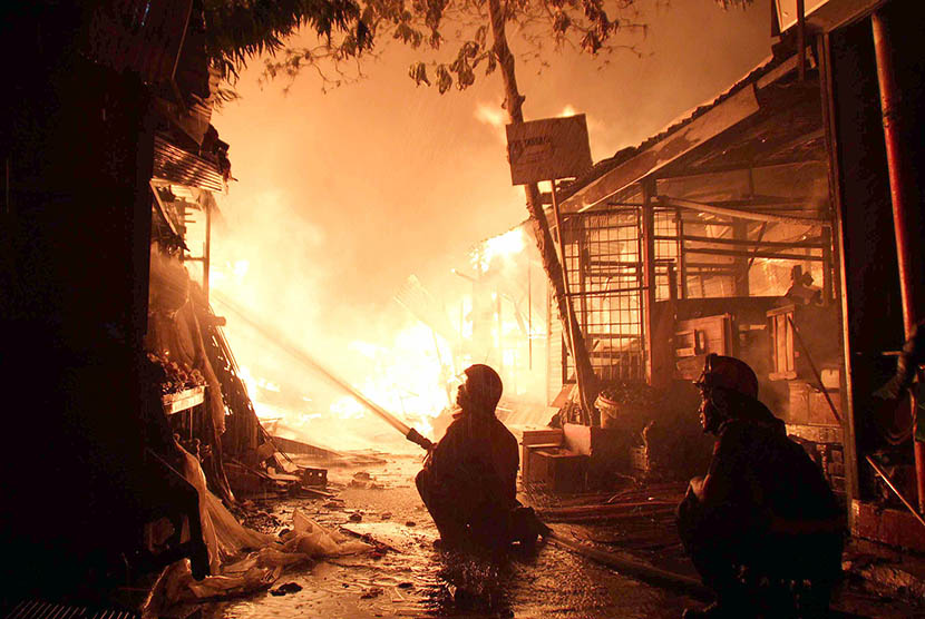  Dua petugas Pemadam Kebakaran Pemkota Semarang memadamkan api yang membakar Pasar Johar Semarang, Ahad (10/5) dini hari. (Republika/Bowo Pribadi)