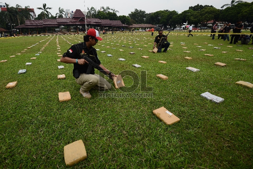 Petugas kepolisian berjaga di depan barang bukti ganja saat rilis pengungkapan sindikat narkotika jenis ganja di Lapangan Bhayangkara Mabes Polri, Jakarta Selatan, Senin (11/5).  (Republika/Raisan Al Farisi)
