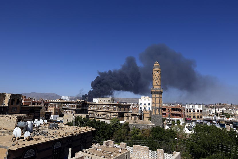  Asap membumbung akibat ledakan yang terjadi di sebuah gudang persenjataan yang dikuasai militan Houthi di kota Sanaa, Selasa (12/5). (EPA/Yahya Arhab)