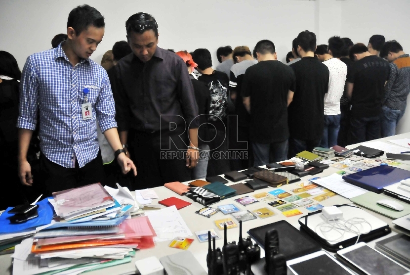 Polisi menunjukkan sejumlah barang bukti dan WNA asal Cina dan Taiwan saat menggelar hasil penangkapan 30 WNA di salah satu ruko di Penjaringan, Jakarta Utara, Selasa (12/5). (Republika/Rakhmawaty La’lang)