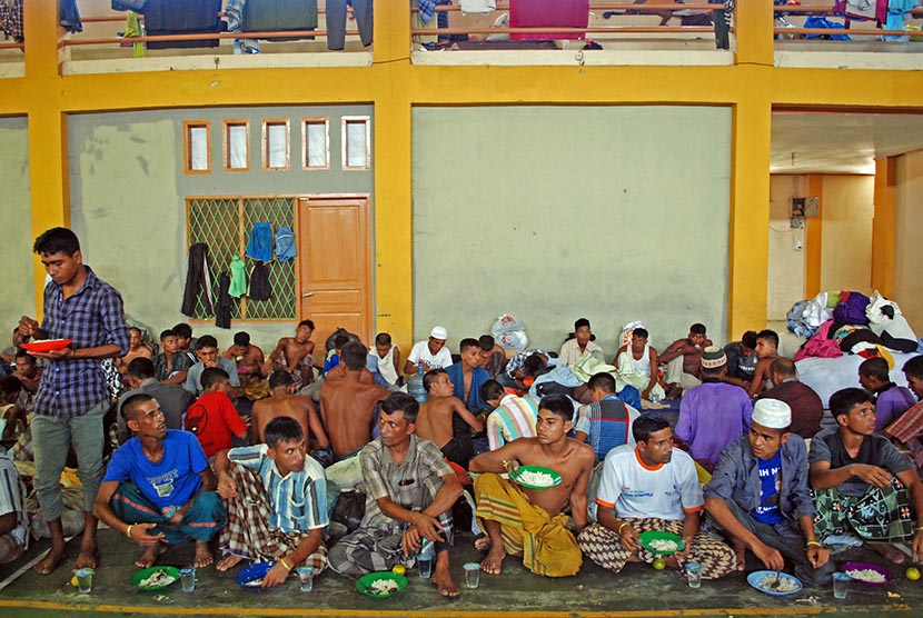 Warga etnis Rohingya makan siang bersama sebelum dipindahkan dari tempat penampungan sementara gedung GOR Lhoksukon, Aceh Utara, Aceh, Rabu (15/3). (Antara/Rony Muharrman)