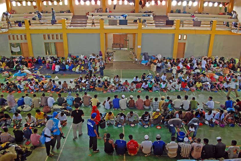   Warga etnis Rohingya makan siang bersama sebelum dipindahkan dari tempat penampungan sementara gedung GOR Lhoksukon, Aceh Utara, Aceh, Rabu (15/3). (Antara/Rony Muharrman)