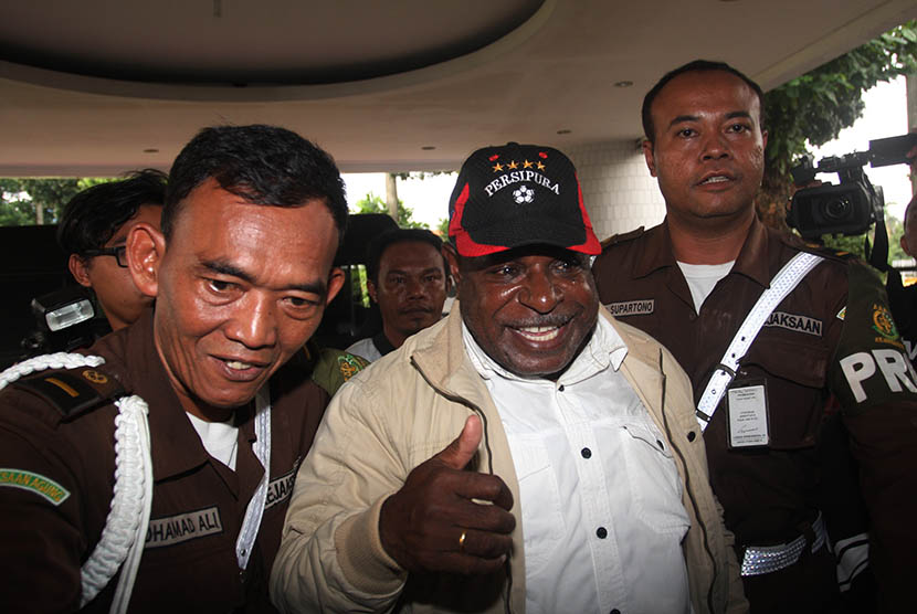 Bupati Sarmi Mesak Manimbor (tengah) dikawal petugas ketika tiba di Gedung Bundar, Kejaksaan Agung, Jakarta Selatan, Kamis (14/5).