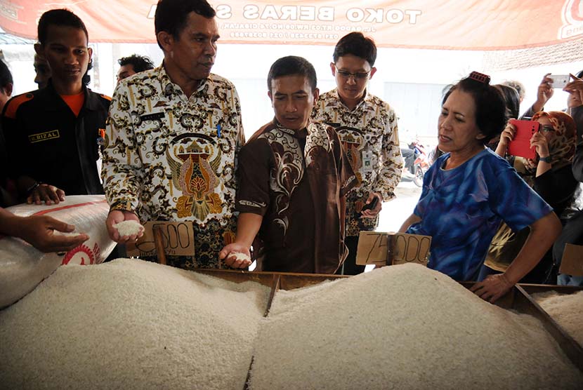 Petugas Dinas Perindustrian dan Perdagangan Kota Depok memeriksa beras yang dijual di salah satu agen saat sidak beras sintetis di Pasar Cisalak, Depok, Jawa Barat, Kamis (21/5).  (Antara/Indrianto Eko Suwarso)