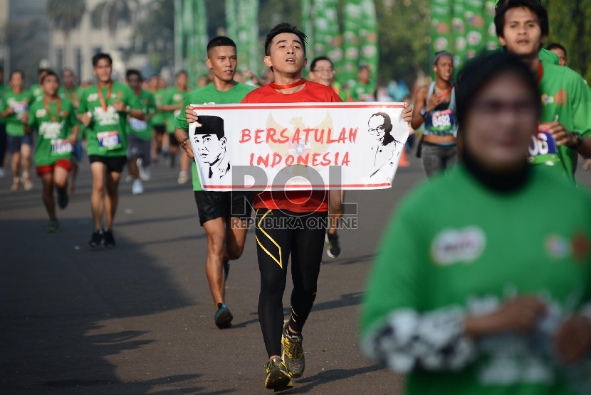  Seorang peserta membawa spanduk dengan pesan Bersatulah Indonesia (ilustrasi)