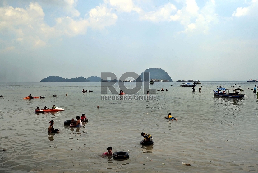 Pengunjung bermain air saat mengunjungi Pantai Pasir Putih, Tarahan, Lampung Selatan,Ahad (31/5). (Republika/Tahta Aidilla)