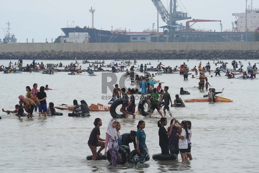 Pengunjung bermain air saat mengunjungi Pantai Pasir Putih, Tarahan, Lampung Selatan,Ahad (31/5). (Republika/Tahta Aidilla)