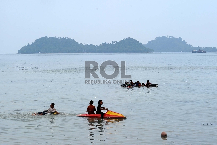 Pengunjung bermain air saat mengunjungi Pantai Pasir Putih, Tarahan, Lampung Selatan,Ahad (31/5). (Tahta Aidilla/Republika)