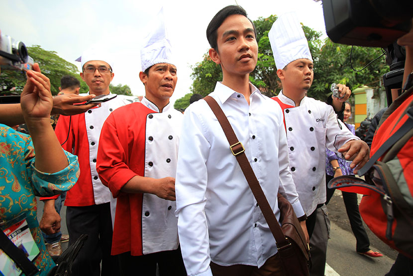 Putra sulung Presiden Joko Widodo, Gibran Rakabuming Raka (dua kanan) bersama sejumlah juru masak berjalan menuju Media Center Jokowi Mantu sebelum memberikan keterangan pers di Sumber, Solo, Jawa Tengah, Selasa (9/6).