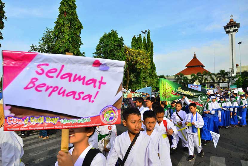   Sejumlah peserta pawai membawa atribut tulisan menyambut bulan puasa di depan alun-alun Kudus, Jawa Tengah, Selasa (9/6). (Antara/Yusuf Nugroho)