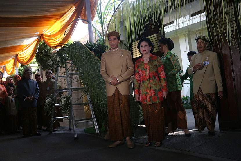 Presiden Joko Widodo (tengah) didampingi Ibu Negara Iriana Joko Widodo (ketiga kanan) bersiap memasang bleketepe di atas gerbang kediamannya di  Jalan Kutai Utara, Sumber, Banjarsari, Solo, Jawa Tengah, Rabu (10/6). (Antara/Setpres-Cahyo Bruri Sasmito)