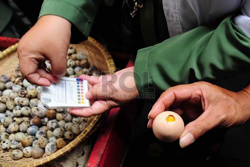   Petugas dari Dinas Ketahanan Pangan melakukan tes kelayakan konsumsi pada telur yang di jual di Pasar Astanaanyar, Kota Bandung, Senin (15/6). (foto : Septianjar Muharam)