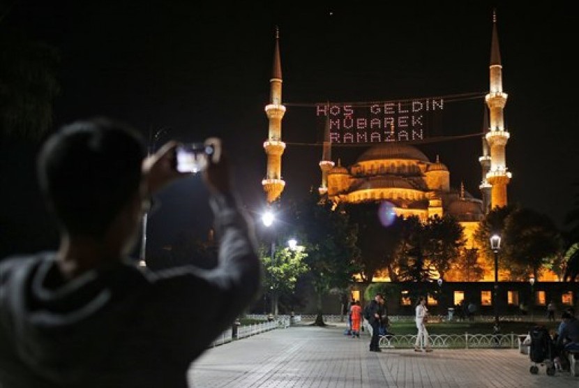  Seorang warga mengabadikan masjid Sultan Ahmed atau yang lebih dikenal dengan masjid Biru di Istanbul, Turki, Rabu (17/6).  (AP/Emrah Gurel)