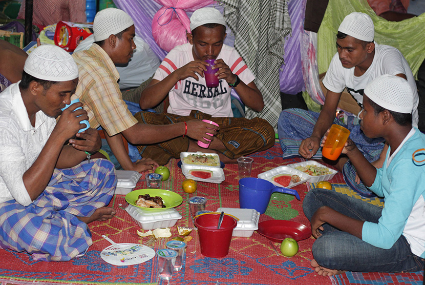  Sejumlah Imigran Rohingya berbuka puasa bersama pada hari pertama bulan suci Ramadan di tempat penampungan sementara Desa Bayeun, Kecamatan Rantoe Seulamat, Kabupaten Aceh Timur, Aceh, Kamis (18/6). (Antara/Syifa)